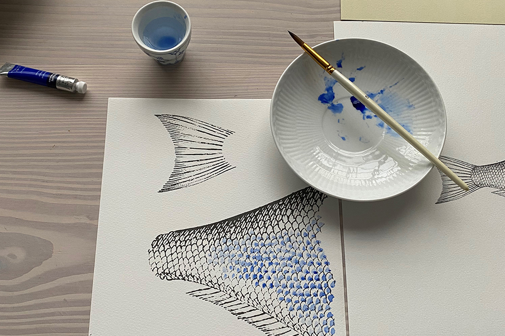 a paint brush and paint on a white plate. You can see they have been used for painting the scales on a fish